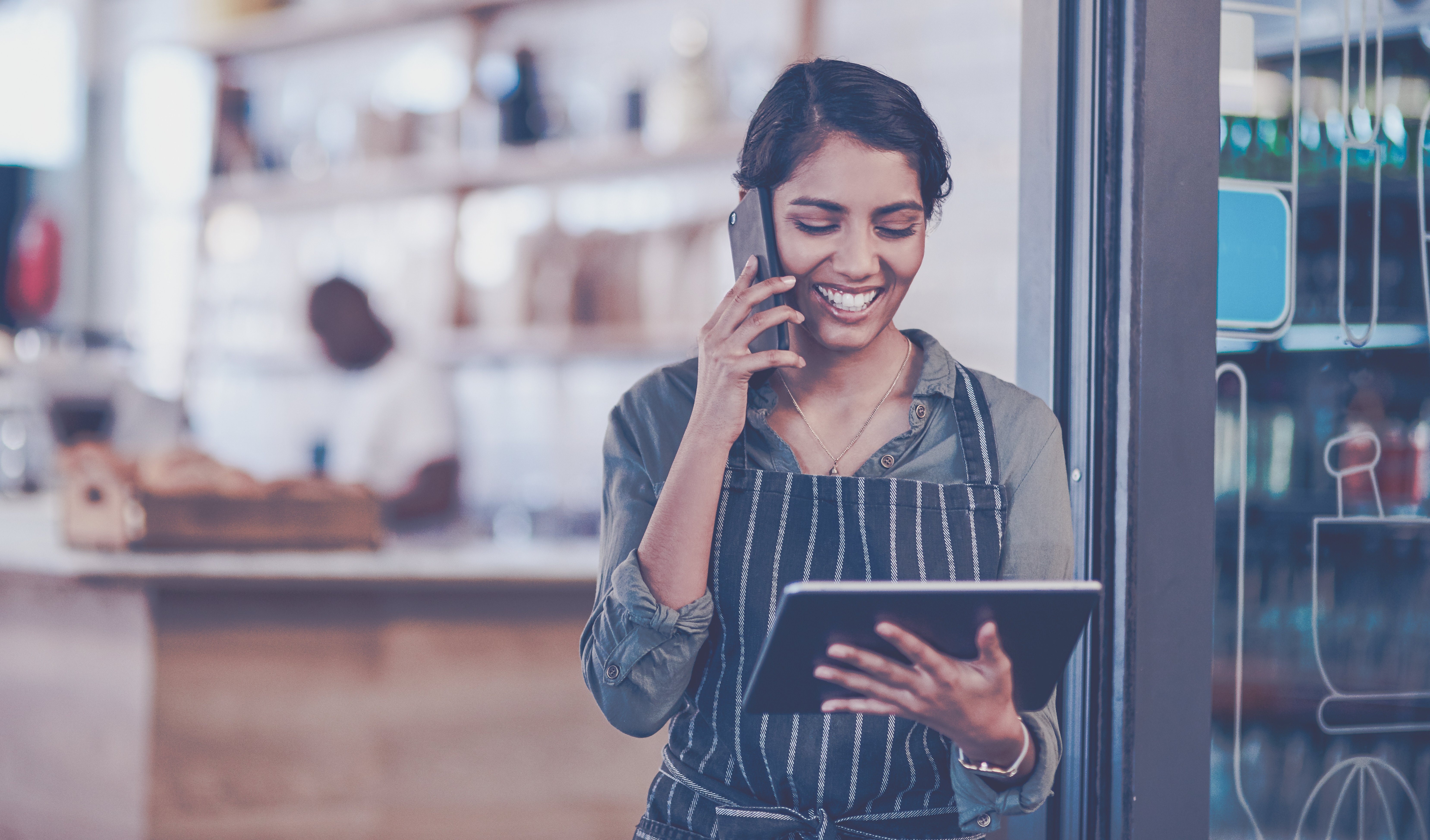 woman on phone looking at tablet